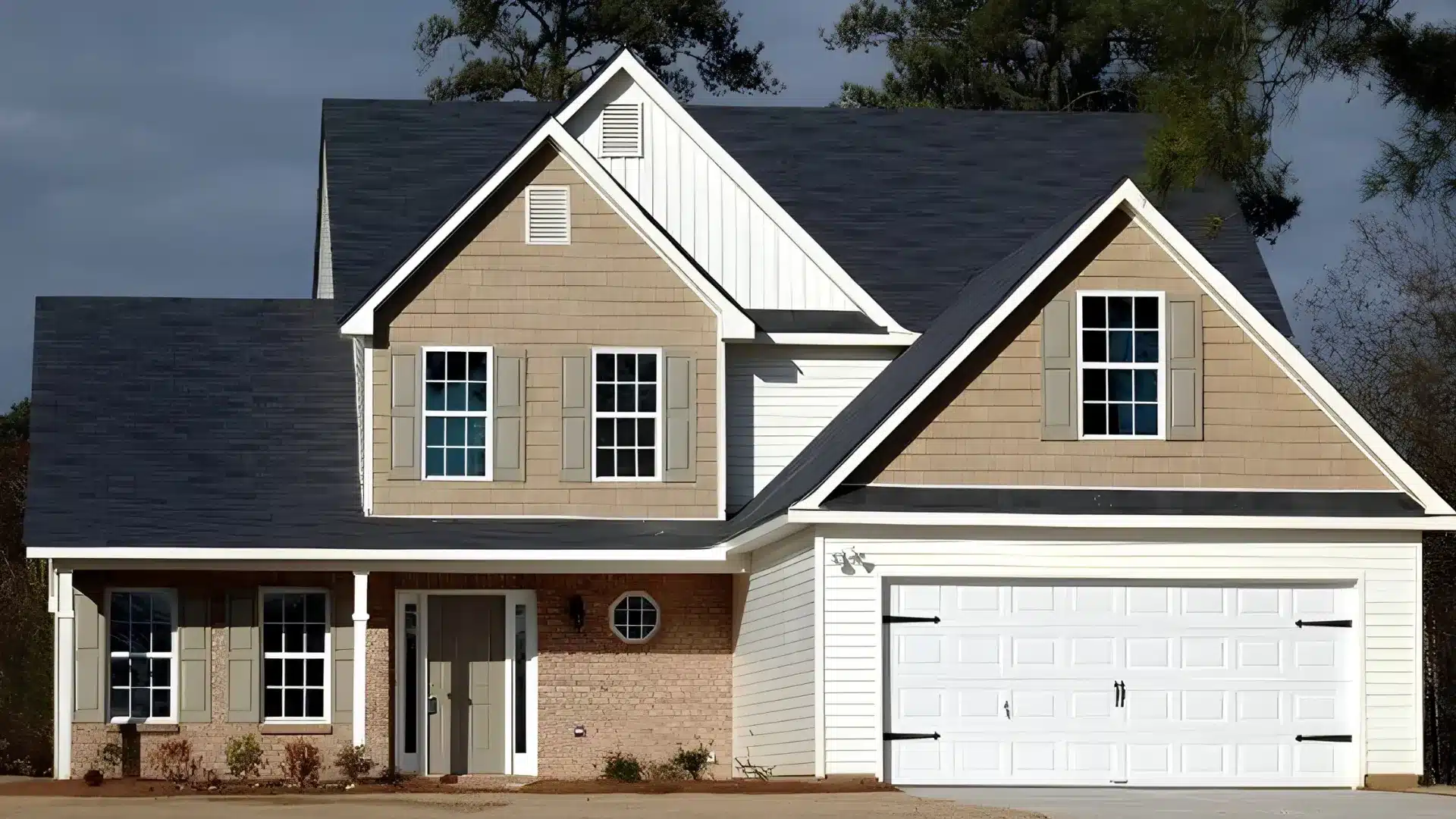 A beige and white two story spec house with a dark shingle roof and a white garage door