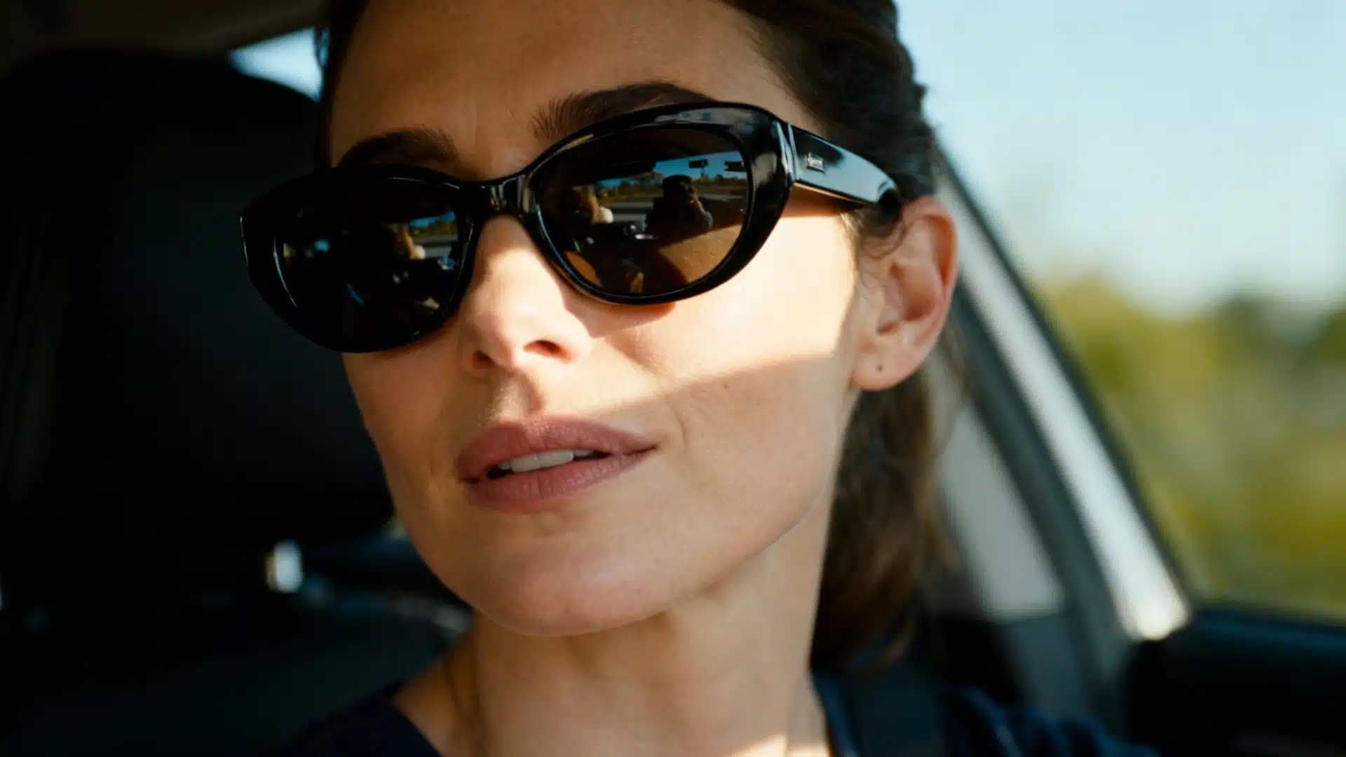 Woman wearing sunglasses sitting in a car